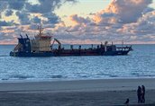 Baggerschip voor de kust